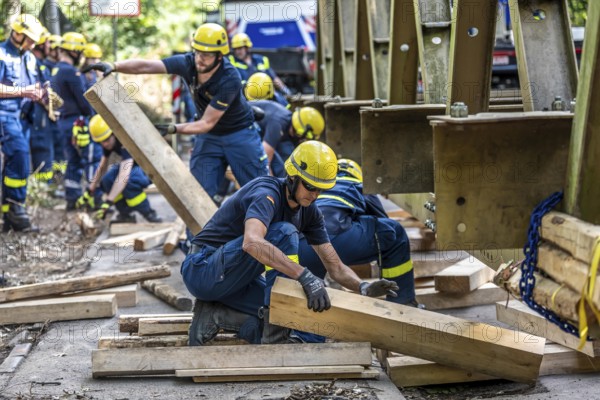 Construction of a temporary bridge over a slipped road crossing a stream, by the bridge construction section of the THW, 18 metre long steel bridge of the Krupp-D type, is assembled in around 8 hours, large-scale exercise FÜLEX25 lasting several days, of the THW North Rhine-Westphalia regional association, over 3500 volunteers from the 127 North Rhine-Westphalia local associations practise on 4 weekends, many different deployment scenarios