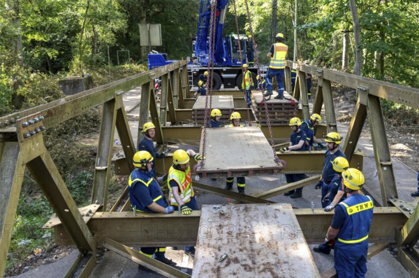 Construction of a temporary bridge over a slipped road crossing a stream, by the bridge construction section of the THW, 18 metre long steel bridge of the Krupp-D type, is assembled in around 8 hours, large-scale exercise FÜLEX25 lasting several days, of the THW North Rhine-Westphalia regional association, over 3500 volunteers from the 127 North Rhine-Westphalia local associations practise on 4 weekends, many different deployment scenarios