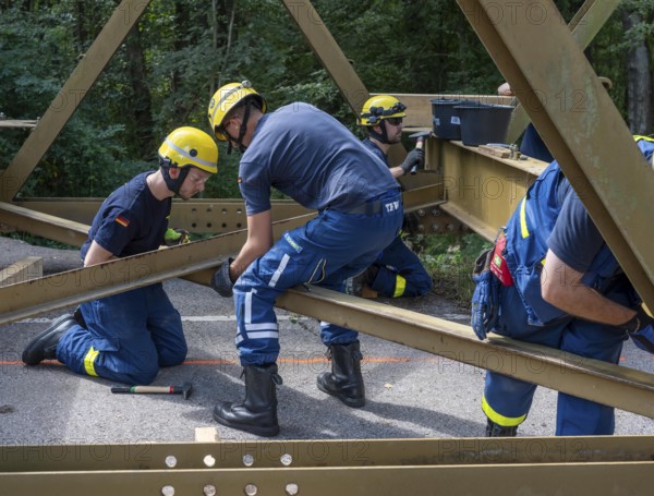 Construction of a temporary bridge over a slipped road crossing a stream, by the bridge construction section of the THW, 18 metre long steel bridge of the Krupp-D type, is assembled in around 8 hours, large-scale exercise FÜLEX25 lasting several days, of the THW North Rhine-Westphalia regional association, over 3500 volunteers from the 127 North Rhine-Westphalia local associations practise on 4 weekends, many different deployment scenarios