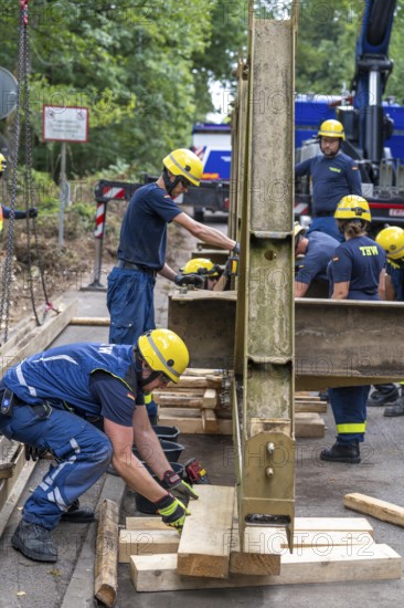 Construction of a temporary bridge over a slipped road crossing a stream, by the bridge construction section of the THW, 18 metre long steel bridge of the Krupp-D type, is assembled in around 8 hours, large-scale exercise FÜLEX25 lasting several days, of the THW North Rhine-Westphalia regional association, over 3500 volunteers from the 127 North Rhine-Westphalia local associations practise on 4 weekends, many different deployment scenarios