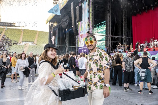 Man in pineapple sunglasses and pineapple shirt with female drinks vendor at Superbloom Festival, Day 1 at Olympiapark, Munich, 30/08/2025