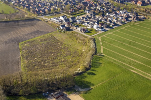 Aerial view, meadow area, single-family houses construction site, new building, residential area Capeller Straße, view of Südkirchen, Nordkirchen, Münsterland, North Rhine-Westphalia, Germany, construction work, construction area, building site, building plots, construction project, construction site, DE, Europe, aerial view, aerial photography, aerial photography, overview, bird's-eye view, overview