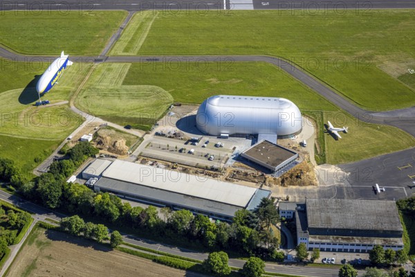 Aerial view, Airport Essen/Mülheim, Goodyear airship Zeppelin, construction site next to the WDL airship hangar, parked aeroplanes, Holthausen - south-east, Mülheim an der Ruhr, Ruhr area, North Rhine-Westphalia, Germany, construction work, construction area, construction site, building plots, construction project, construction site, DE, Europe, aerial view, aerial photography, aerial photography, overview, bird's-eye view, overview