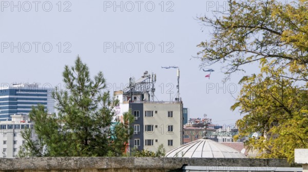Türkiye special operations police hang from a helicopter with ropes, carrying weapons and unfurling a large Turkish flag while saluting citizens during an aerobatic air show at Teknofest technology festival. Gaziantep, Türkiye. September 24, 2020, Gaziantep, Gaziantep, Türkiye