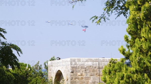 Türkiye special operations police hang from a helicopter with ropes, carrying weapons and unfurling a large Turkish flag while saluting citizens during an aerobatic air show at Teknofest technology festival. Gaziantep, Türkiye. September 24, 2020, Gaziantep, Gaziantep, Türkiye