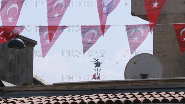 Türkiye special operations police hang from a helicopter with ropes, carrying weapons and unfurling a large Turkish flag while saluting citizens during an aerobatic air show at Teknofest technology festival. Gaziantep, Türkiye. September 24, 2020, Gaziantep, Gaziantep, Türkiye
