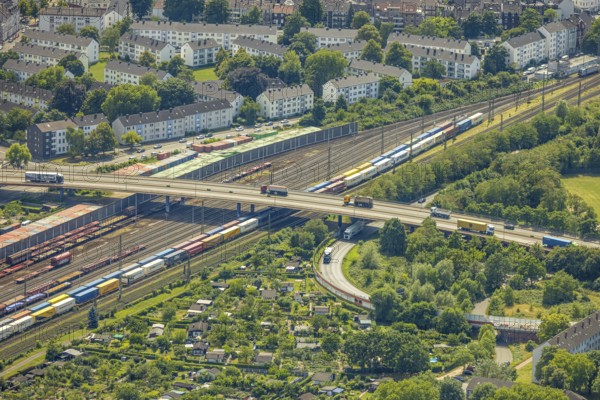 Aerial view, railway line with container site and bridge Friedrich-Ebert-Straße with curved road Zum Logport, tenement houses housing estate between Kruppstraße and Kronprinzenstraße, allotment garden site Zur Bahn, Friemersheim, Duisburg, Ruhr area, North Rhine-Westphalia, Germany, railway tracks, bridge, DE, railway tracks, Europe, community garden, allotment garden, allotment garden site, allotment garden association, allotment gardener association, allotment garden colony, aerial view, aerial photography, aerial photography, allotment garden, overview, bird's eye view, birds-eyes view, overview