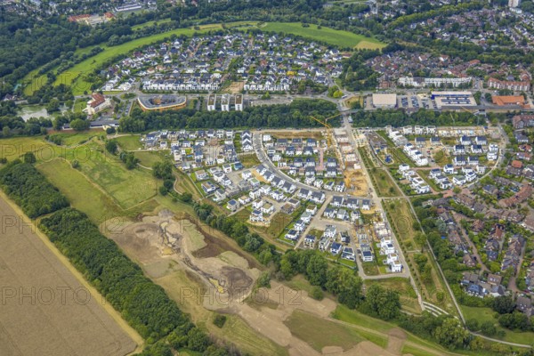 Aerial view, Duisburg-Süd, residential area Angerbogen, Am Alten Angerbach, semi-circular new housing estate, commercial area Xella International GmbH and Edeka E-Center Angerbogen, roofed railway station Angerbogen, behind the Rahmer See, Huckingen, Duisburg, Ruhr area, North Rhine-Westphalia, Germany