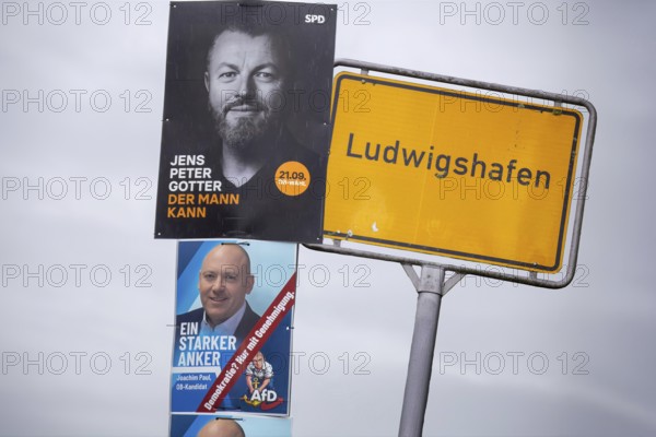 (Photomontage) Town sign and election posters for the mayoral election in Ludwigshafen: Jens Peter Gotter (SPD) at the top, below the poster of the excluded candidate Joachim Paul (AfD)