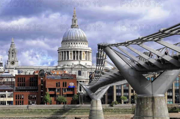 St Paul's Cathedral next to the Millennium Bridge under a dramatic sky, London, England, United Kingdom