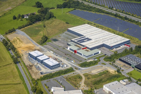Aerial view, industrial area Enste-Süd with solar park Enste at the motorway A46, construction site with new building logistics centre Briloner Leuchten GmbH, Enste, Meschede, Sauerland, North Rhine-Westphalia, Germany, motorway A46, construction work, construction area, construction site, building plots, construction project, construction site, DE, Europe, commercial enterprises, commercial area, commercial area, commercial park, commercial site, commercial use, large construction site, industrial area, industrial building, industrial site, aerial view, aerial photography, aerial photography, new construction, photovoltaic, photovoltaic plant, Ruhr area, solar, solar plant, solar energy, solar park, overview, bird's-eye view, birds-eyes view, overview