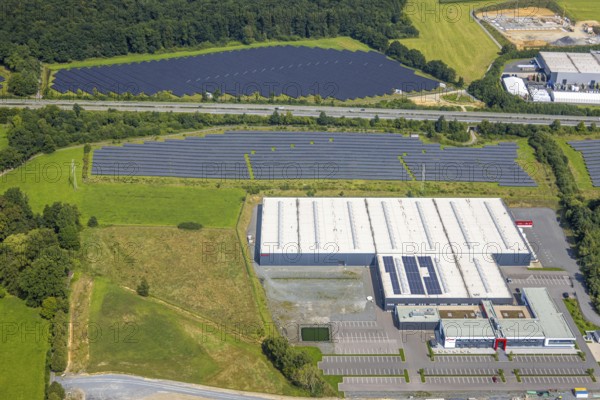 Aerial view, industrial area Enste-Süd with solar park Enste at the motorway A46, construction site with new building logistics centre Briloner Leuchten GmbH, Enste, Meschede, Sauerland, North Rhine-Westphalia, Germany, motorway A46, construction work, construction area, construction site, building plots, construction project, construction site, DE, Europe, commercial enterprises, commercial area, commercial area, commercial park, commercial site, commercial use, large construction site, industrial area, industrial building, industrial site, aerial view, aerial photography, aerial photography, new construction, photovoltaic, photovoltaic plant, Ruhr area, solar, solar plant, solar energy, solar park, overview, bird's-eye view, birds-eyes view, overview