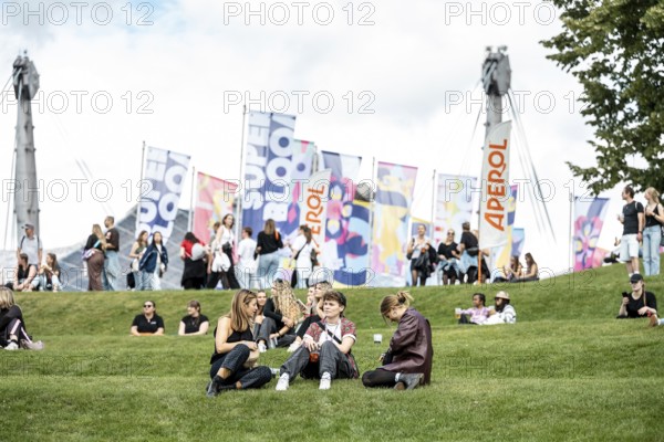 Visitors relaxing in a meadow at the Superbloom Festival, Day 1 in the Olympic Park, Munich, 30/08/2025