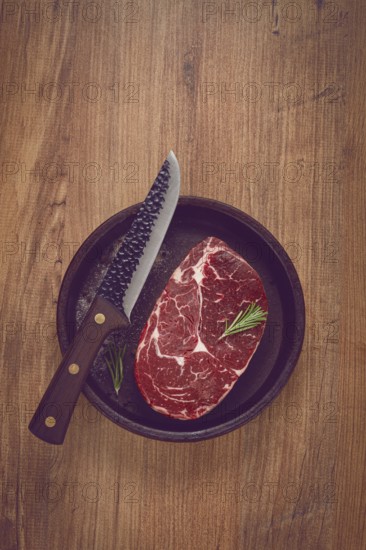 Steak made from fresh beef, with herbs and various spices, in a clay pan, with a kitchen knife, ready to cook, no people