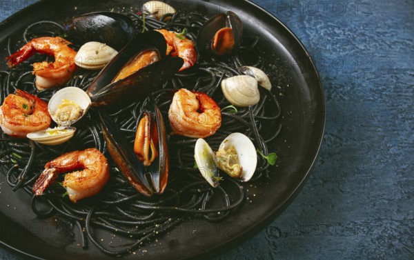 Black spaghetti, with shrimp and mussels, vongole, on a black plate, spaghetti with shrimp, spaghetti with mussels, top view, no people