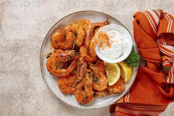 Fried white-footed shrimp, tiger prawns vannamey, on a plate, with lemon and herbs, no people