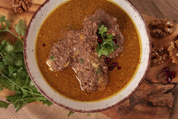 Fesenjan, an Iranian dish, stewed chicken, in a nut-pomegranate sauce, in a bowl, homemade, no people