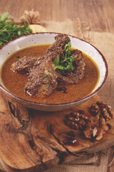 Fesenjan, an Iranian dish, stewed chicken, in a nut-pomegranate sauce, in a bowl, homemade, no people