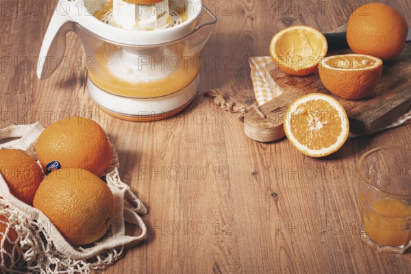 Preparation of freshly squeezed orange juice, using a juicer, in a cozy kitchen setting