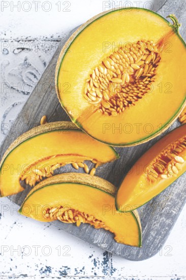 Freshly sliced melon slices, cantaloupe melon, on a wooden chopping board, close-up