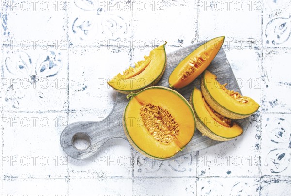 Freshly sliced melon slices, cantaloupe melon, on a wooden chopping board, close-up