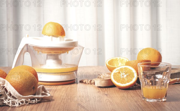 Preparation of freshly squeezed orange juice, using a juicer, in a cozy kitchen setting