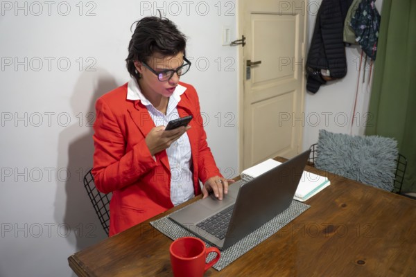 Modern professional having a phone meeting while working on a laptop