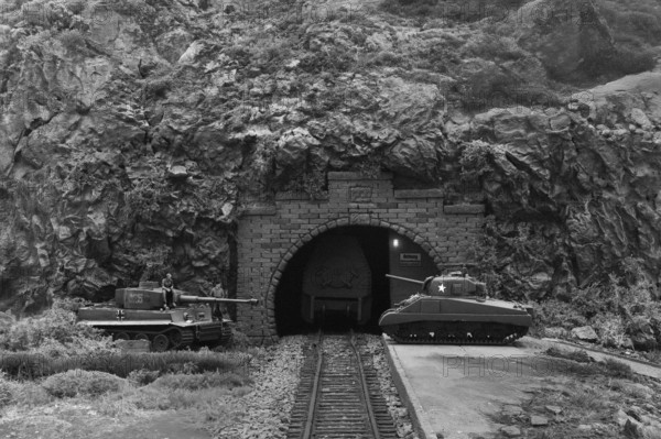 Diorama: Tiger and Sherman tanks in front of a mountain tunnel with tracks