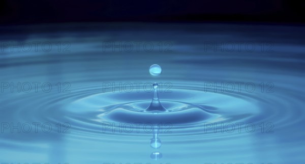 A captivating macro shot of a water droplet creating ripples and reflections, set against a dark blue backdrop. The image shows a water drop and the resulting splash, AI generated