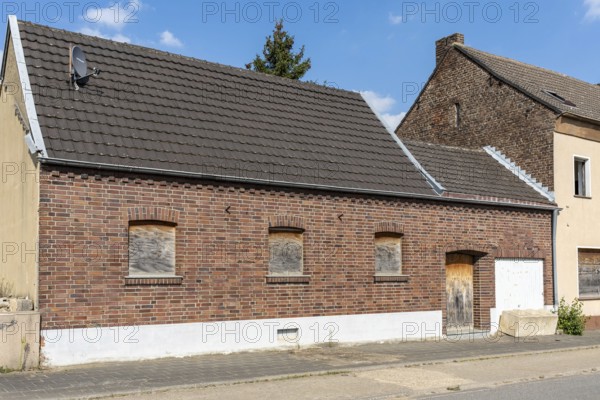 Brick house with barricaded windows and garage door, Manheim, North Rhine-Westphalia, Germany