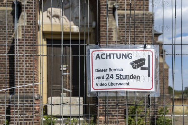 Warning sign Video surveillance in front of church behind fence, Manheim, North Rhine-Westphalia, Germany
