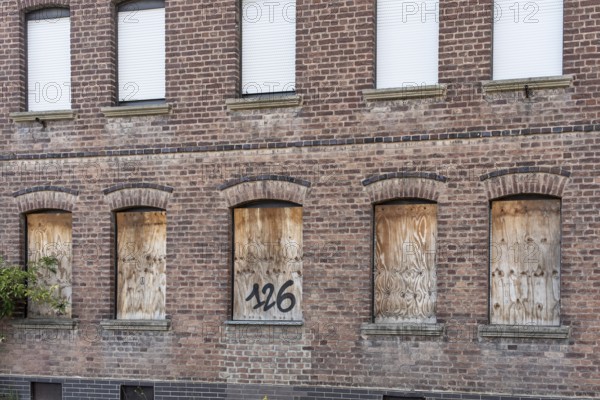 Old brick house façade with boarded-up windows, Manheim, North Rhine-Westphalia, Germany