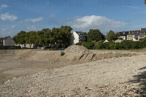 Excavation pit with houses in the background, Ehrenfeld, Cologne, North Rhine-Westphalia, Germany