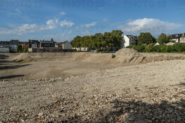 Excavation pit with houses in the background, Ehrenfeld, Cologne, North Rhine-Westphalia, Germany
