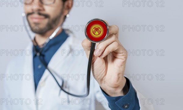 Doctor holding stethoscope with Kyrgyzstan flag. Kyrgyzstan health and care concept, Kyrgyzstan flag on stethoscope