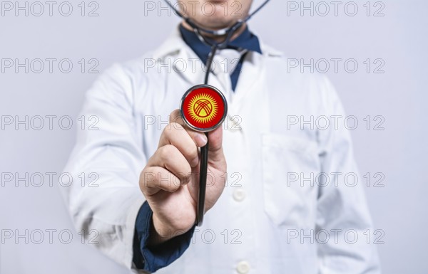 Doctor hands holding stethoscope with Kyrgyzstan flag. Kyrgyzstan health and care concept