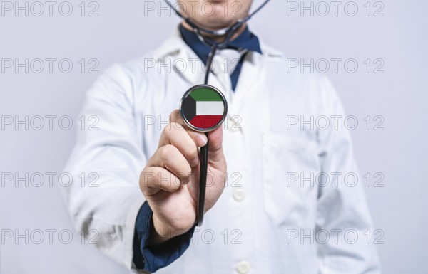 Doctor hands holding stethoscope with Kuwait flag. Kuwait health and care concept