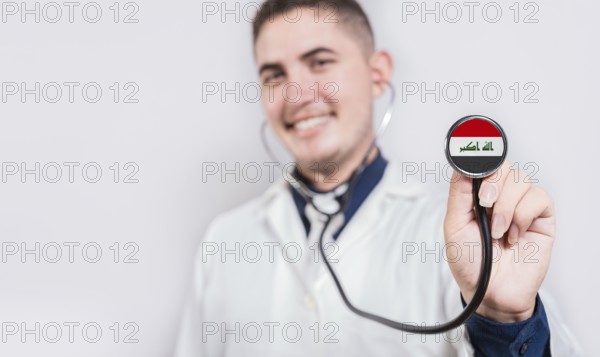 Doctor showing stethoscope with Iraq flag. Iraq national healthcare concept