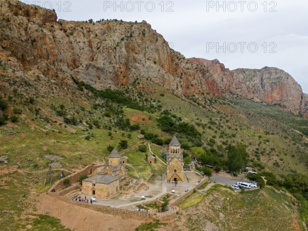Church landscape in front of dramatic rock formations, surrounded by green nature, in a secluded mountain location, aerial view, Noravank Monastery, on the right mausoleum church Surb Astvatsatsin and on the left Baptist church Surb Karapet, Noravank, Vayots Dzor province, Vayots Dzor, Armenia, Caucasus