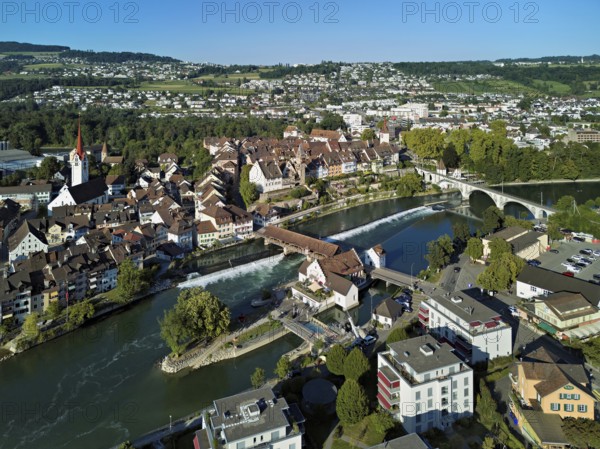 Old town with the Catholic Church of St Nicholas and the tower of the Muri- Amthof, in the foreground the weir and the museum Reusskraftwerk Bruggmühle on the river Reuss, Bremgarten, Freiamt, Canton, Aargau, Switzerland