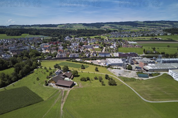 View of the village with the Catholic parish church of the Nativity of the Virgin Mary, industrial area on the right, Sins, Freiamt, Canton Aargau, Switzerland