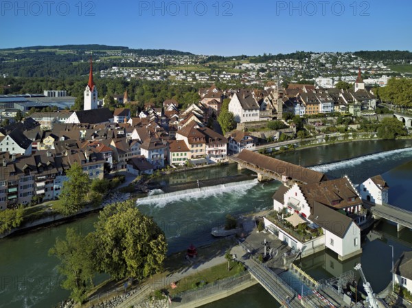 Old town with the Catholic Church of St Nicholas and the tower of the Muri- Amthof, in the foreground the weir and the museum Reusskraftwerk Bruggmühle on the river Reuss, Bremgarten, Freiamt, Canton, Aargau, Switzerland