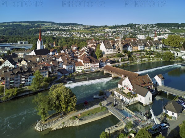 Old town with the Catholic Church of St Nicholas and the tower of the Muri- Amthof, in the foreground the weir and the museum Reusskraftwerk Bruggmühle on the river Reuss, Bremgarten, Freiamt, Canton, Aargau, Switzerland