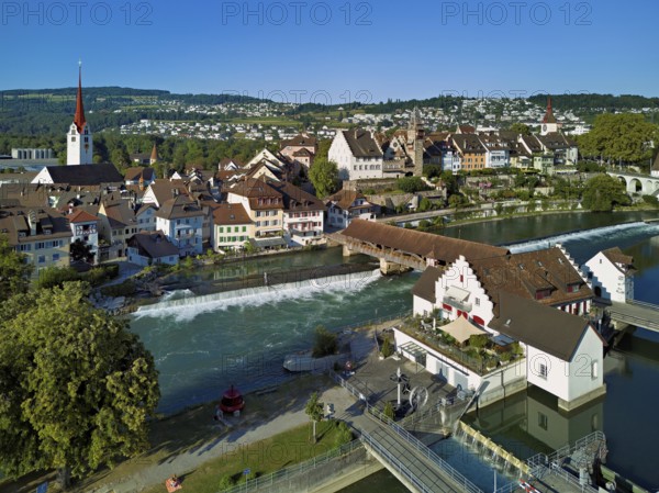 Old town with the Catholic Church of St Nicholas and the tower of the Muri- Amthof, in the foreground the weir and the museum Reusskraftwerk Bruggmühle on the river Reuss, Bremgarten, Freiamt, Canton, Aargau, Switzerland