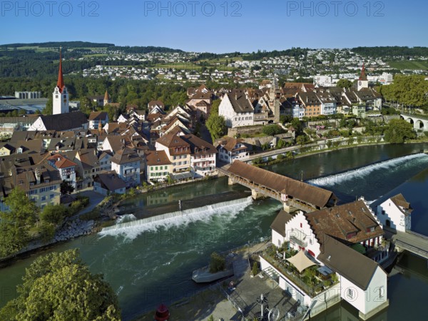 Old town with the Catholic Church of St Nicholas and the tower of the Muri- Amthof, in the foreground the weir and the museum Reusskraftwerk Bruggmühle on the river Reuss, Bremgarten, Freiamt, Canton, Aargau, Switzerland