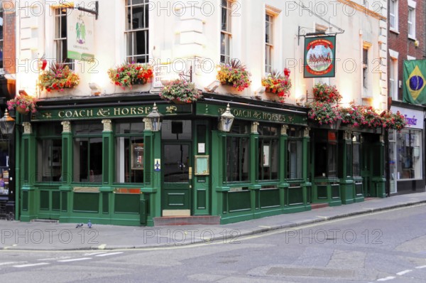 London, England, Great Britain, Europe, Traditional British pub façade with green painting and floral decoration