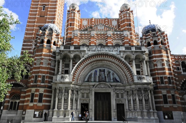 Partial view of Westminster Cathedral, London, England, Great Britain, Europe, Magnificent Gothic brick cathedral with detailed facade and high towers under a blue sky, London region