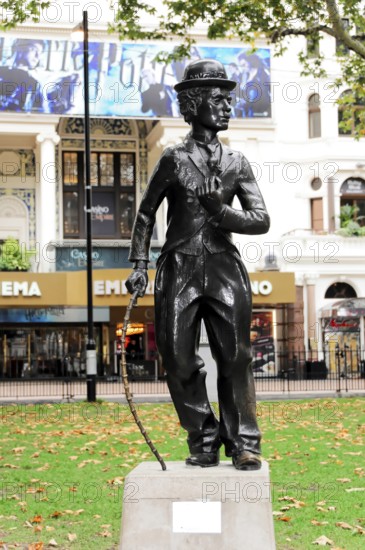 London, England, Great Britain, Europe, Bronze statue of Charlie Chaplin in front of a cinema in a park with autumn leaves