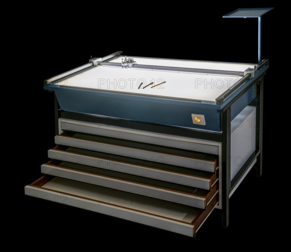 Illuminated layout table with open drawers isolated in black back
