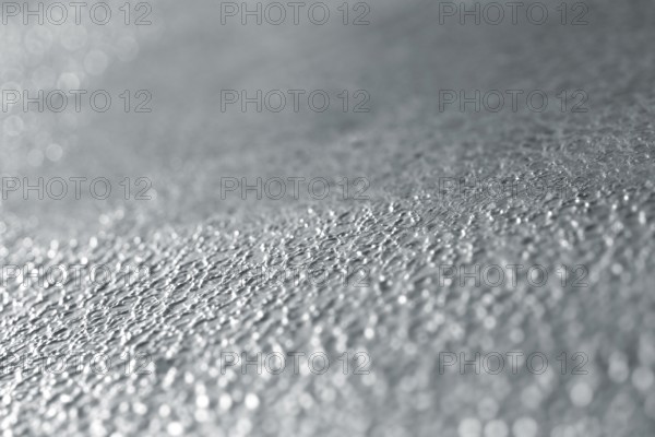Full frame abstract background of a rough metallic surface, focus in the middle part